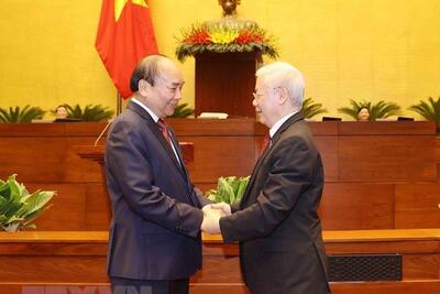Tổng Bí thư Nguyễn Phú Trọng chúc mừng Chủ tịch nước Nguyễn Xuân Phúc. (Ảnh: Trí Dũng/TTXVN)